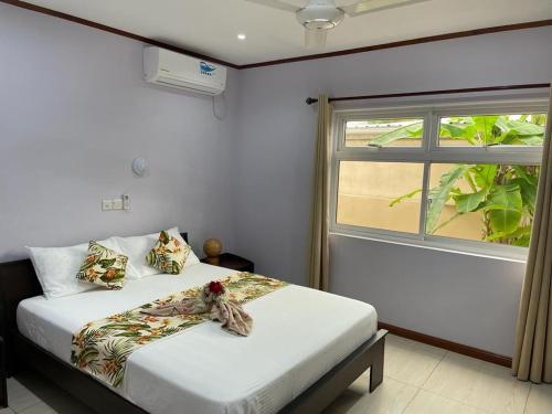 马埃岛Mokara Holiday Apartment的一间卧室设有两张床和窗户。