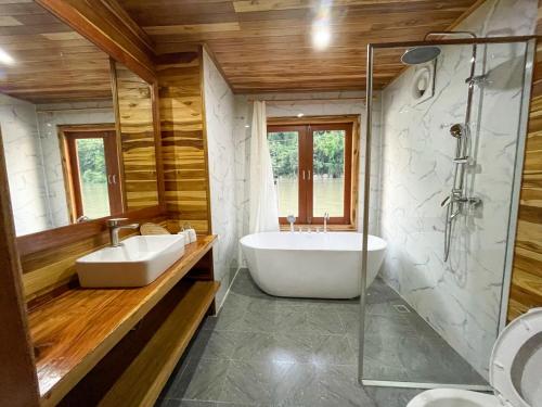 NongkhiawNongkhiaw The Float House的浴室配有2个盥洗盆、浴缸和淋浴。