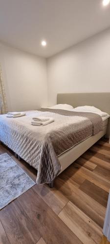 林雪平Stenhuset的卧室内的一张大床,铺有木地板