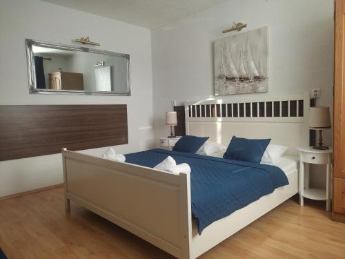 布拉迪斯拉发Spa & Pool Apartment Hotel - Restaurant VILLA IVICA的一间卧室配有一张带蓝色床单和镜子的床