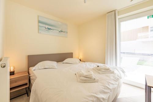 尼乌波特Sailorshouse的卧室配有带毛巾的大型白色床