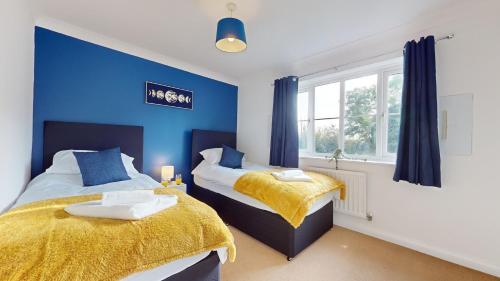 Duxford Deluxe的蓝色墙壁客房的两张床