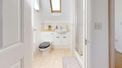 Duxford Deluxe的白色的浴室设有卫生间和水槽。