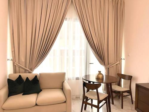 Al QurayyahClassy Studio in Masdar City的带沙发、桌子和窗户的客厅