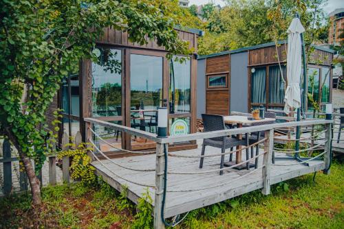 里泽Danzi camping tiny house的房屋设有1个带桌子和遮阳伞的甲板