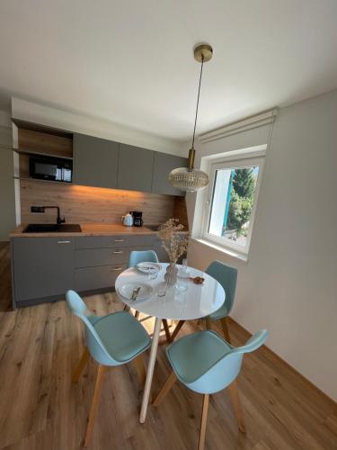 修希Amontis Dolomites的厨房配有白色的桌子和蓝色的椅子