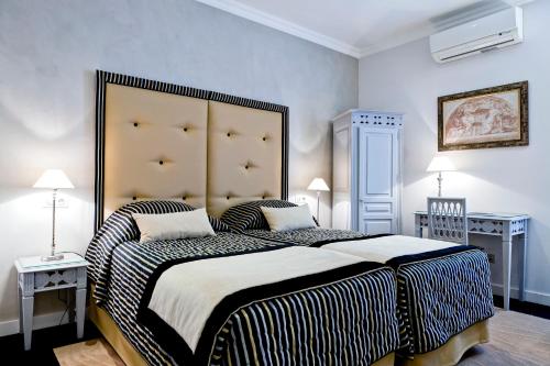里昂格兰德酒店的一间卧室配有一张大床和大床头板
