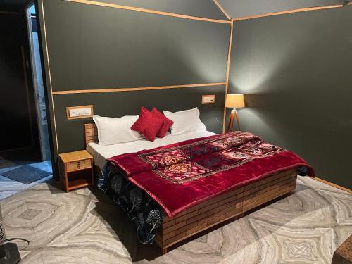 卡索尔Kabila Camp的一间卧室配有一张床铺,床上铺有红色毯子