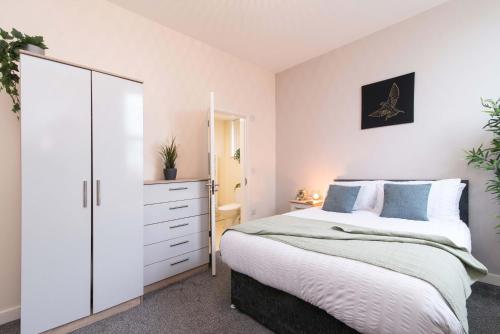 德比cheerful double en-suite with free wifi的卧室配有白色大床和梳妆台