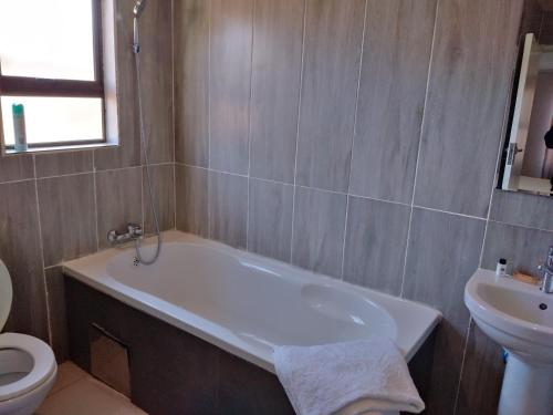 卡萨内Chobe Blue Guest Inn的带浴缸、卫生间和盥洗盆的浴室