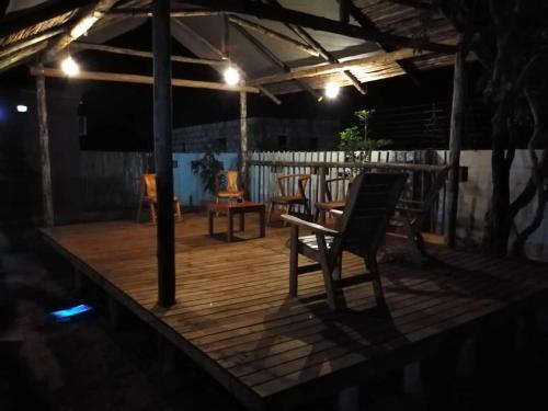 卡萨内Chobe Blue Guest Inn的木制甲板配有椅子和桌子