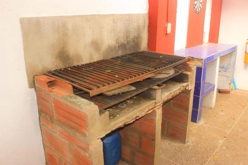 塔甘加Sierraventura Hostel的砖墙顶上的烤架