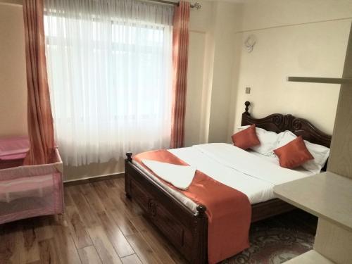 内罗毕JVhomes2bedroom-Ndemi gardens的一间卧室设有一张大床和一个窗户。