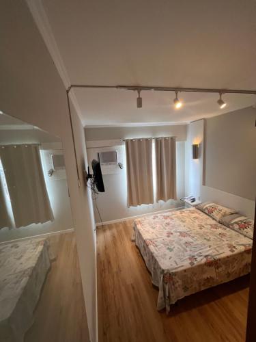 约恩维利Loft no centro de Joinville的一间卧室配有两张床和电视。