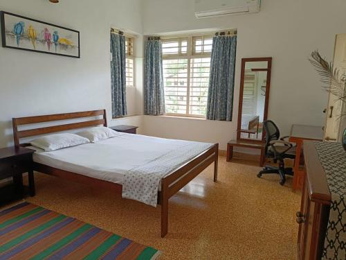 艾哈迈达巴德Srinekatan Heritage Villa Homestay的一间卧室配有一张床、一张书桌和一面镜子
