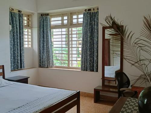艾哈迈达巴德Srinekatan Heritage Villa Homestay的一间卧室配有一张床、镜子和椅子