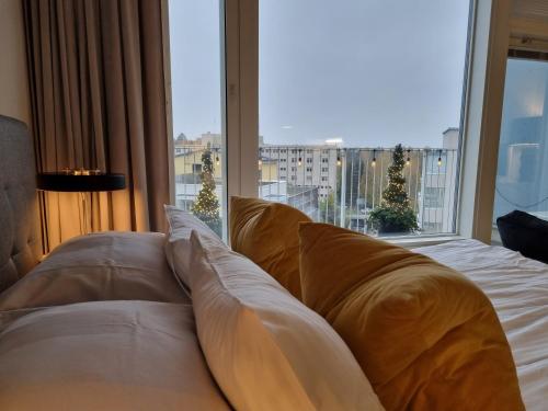 赫尔辛基Premier Residences Helsinki的一张带枕头的床,位于大窗户前