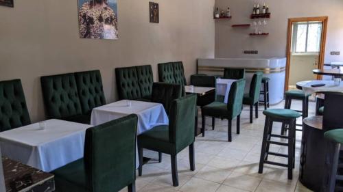 DschangJAD HOTEL Dschang的用餐室配有桌子和绿色椅子