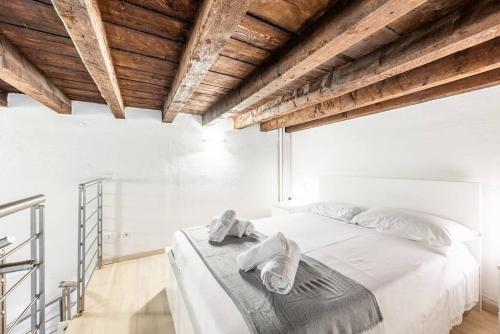 米兰Duomo 10 minutes away - Loft with Wifi and Netflix的卧室配有白色床和毛巾