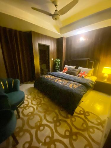 伊斯兰堡Viceroy Executive Hotel Apartments Islamabad的一间卧室配有一张床和一张蓝色椅子
