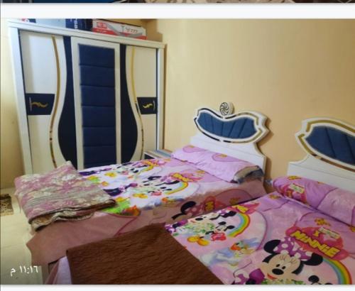 卢克索Luxor downtown的一间卧室配有两张床、小圆顶猫床单和一张米基床。