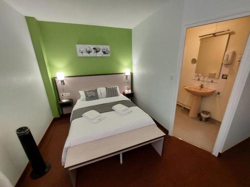 La ChâtaigneraieLe 120 - Groupe Logis Hotels - Ex Auberge la Terrasse的一间卧室配有一张床,浴室设有水槽
