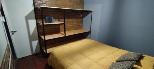 门多萨Casa Céntrica para 7 personas Estacionamiento Gratuito的一间小卧室,配有床和书架