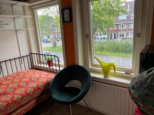 乌得勒支BeBaBops Homestay Utrecht的卧室配有床、椅子和窗户。