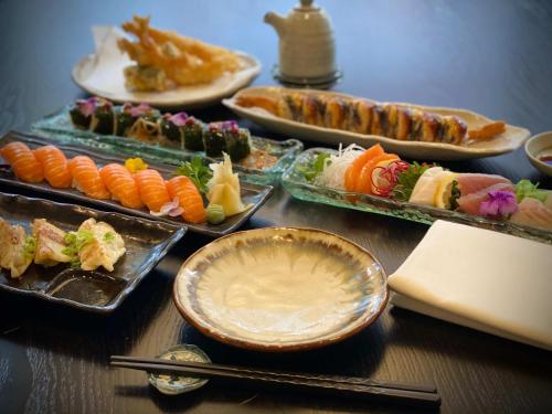 温彻斯特Kyoto Rooms Winchester的配上寿司和其他食物的桌子