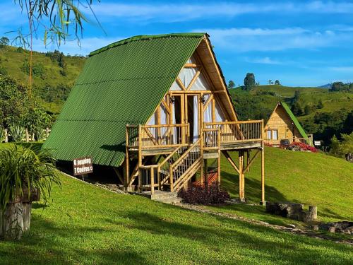 圣罗莎德卡瓦尔Glamping La Herradura的一座带绿色屋顶的大型木制房屋