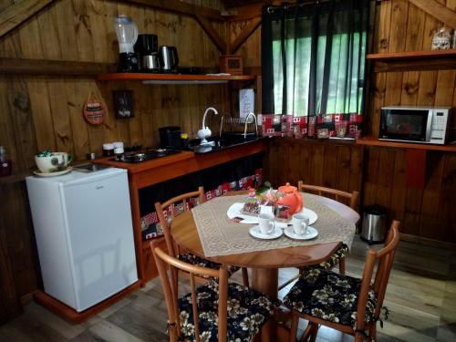 格拉玛多Encosta Dos Pinheiros的厨房配有木桌和桌椅