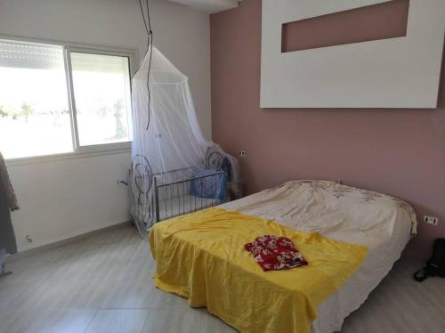 Hammamet Sudmaison spacieuse et lumineuse的一间卧室配有一张黄色毯子床