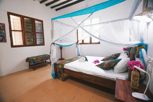 江比阿Cozy Lodge - Guesthouse的一间卧室配有一张带天蓬的床