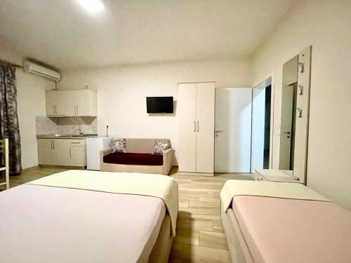 都拉斯Hotel Vila Dedej的带两张床的房间和带沙发的厨房