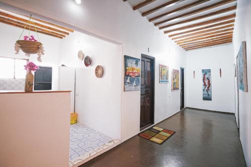 江比阿Cozy Lodge - Guesthouse的一间拥有白色墙壁的客房和一个带绘画的走廊