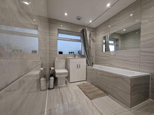 切森特Oakwood Suite - Sleeps 5 - Contractors - Smart TVs in all rooms的带浴缸、卫生间和盥洗盆的浴室