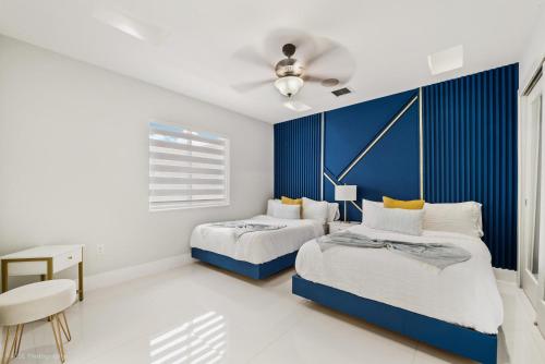 海里亚市Peaceful Rental Retreat in Miami Jacuzzi, BBQ L25的一间卧室设有两张床和蓝色的墙壁