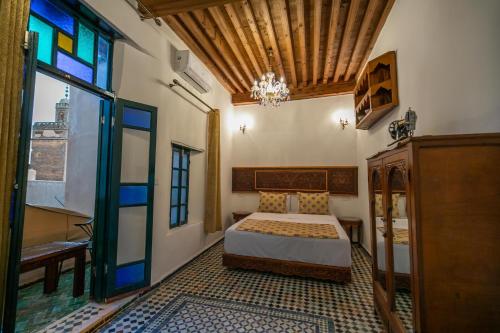 非斯Dar Usham Fes的一间卧室设有一张床和一个彩色玻璃窗