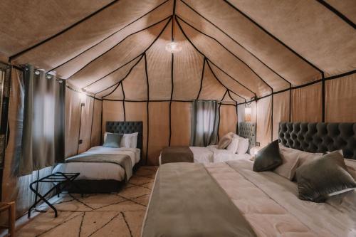 Adrouinedesert camp的帐篷内带两张床的房间