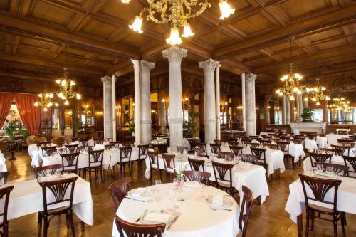 卢尔德现代大酒店的宴会厅配有白色的桌椅