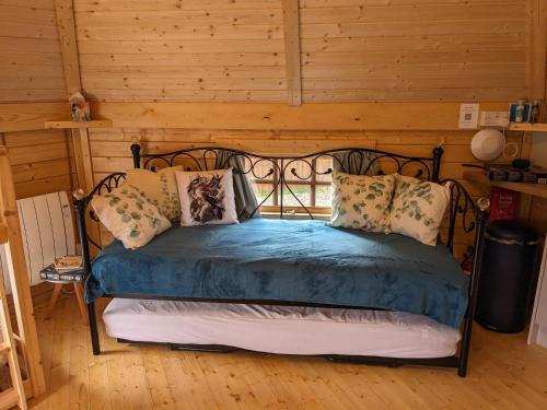 西莫林Woods Meadow Glamping的一间卧室配有一张带蓝色床单和枕头的床。