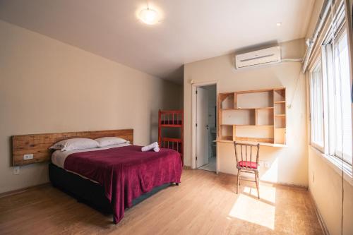 佩洛塔斯Pelotas Bier Hostel的卧室配有床、椅子和窗户。