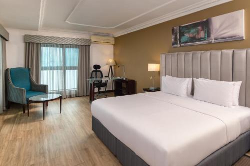 拉各斯拉各斯库拉莫水万豪Protea酒店的酒店客房带一张大床和一把椅子