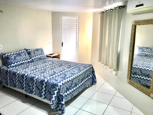 巴雷里尼亚斯Porto Dos Lençóis-Apt 12的卧室配有蓝色和白色的床和镜子