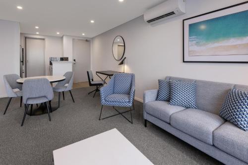 黄金海岸布罗德海滩美利通公寓式酒店的客厅配有沙发和桌椅