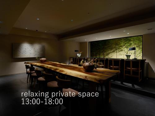 京都京都祗园塞莱斯廷酒店的大房间设有一张长木桌子和椅子