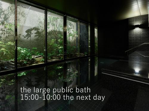京都京都祗园塞莱斯廷酒店的大型公共浴池,透过窗户可以看到森林