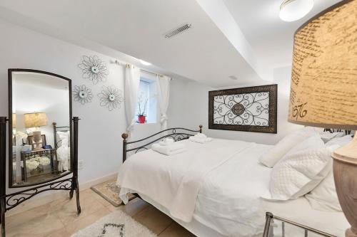 明尼阿波利斯AMAZING TRADITIONAL HOME SOUTH MINNEAPOLIS的卧室配有白色的床和镜子