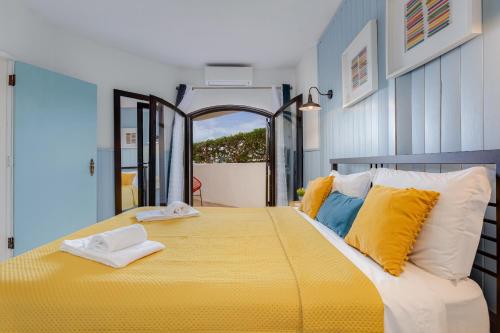 卡武埃鲁Casa Flor de Sal Apartment的一间卧室配有黄色的大床和黄色枕头