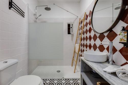 卡武埃鲁Casa Flor de Sal Apartment的一间带水槽、卫生间和镜子的浴室